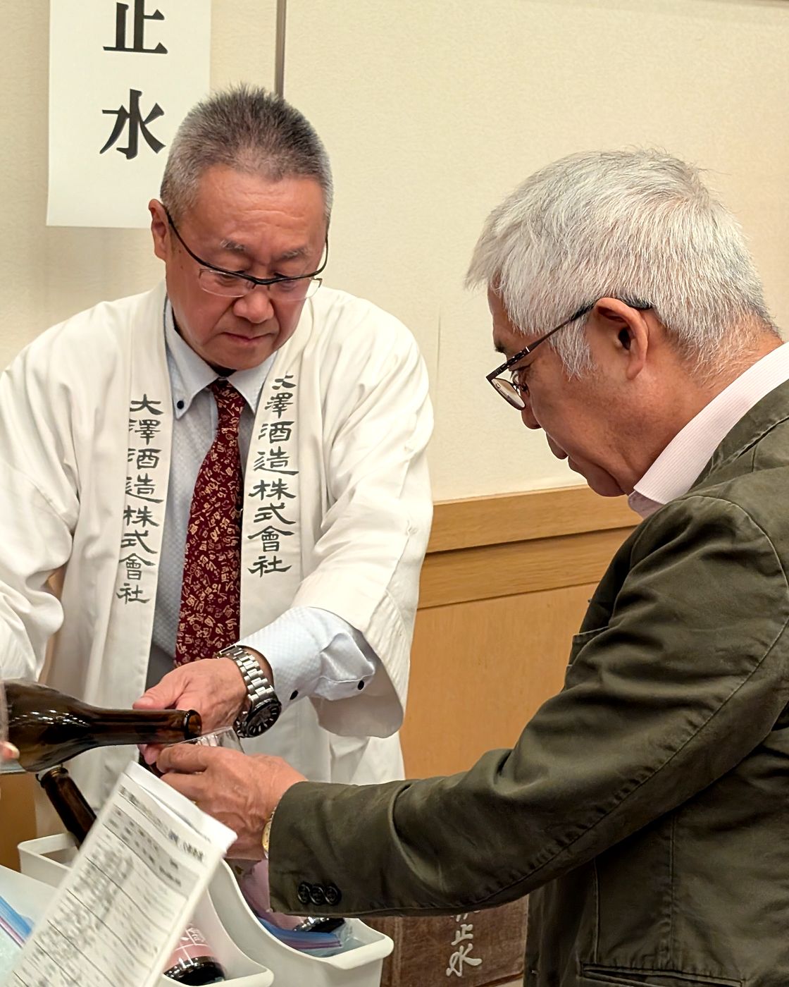 明鏡止水のブースで日本酒を注いでいただく様子