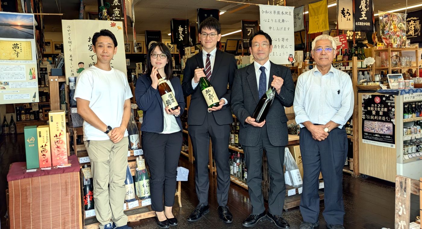店頭で、信濃錦のお酒を手にした宮島酒店の皆さまとの記念写真
